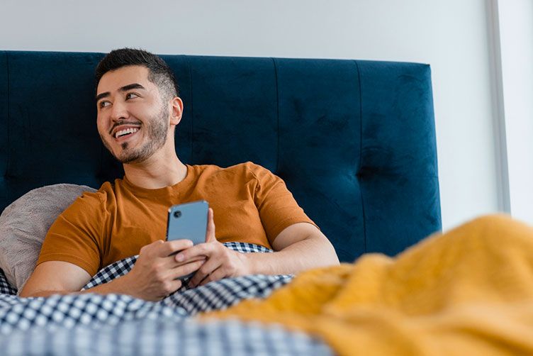 man on phone in bed