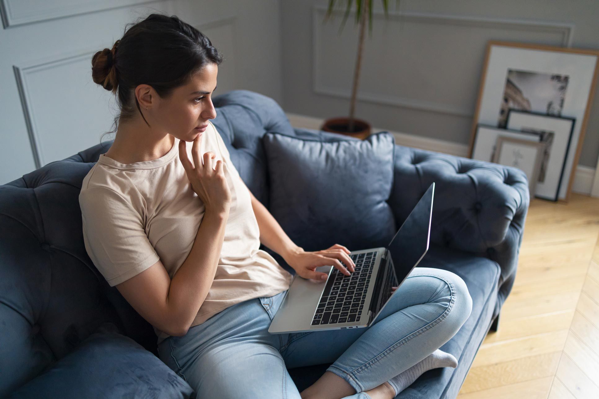 pensive woman on laptop at home