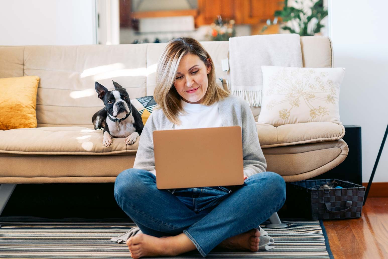 woman sitting on lounge floor using laptop